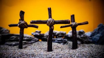 des croix coincé dans le le sable sur un Orange Contexte photo