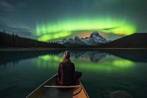 voyageur femme séance sur canoë avec aurore borealis plus de esprit île dans maligne Lac à jaspe nationale parc, alberta, Canada photo