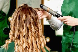 coiffeur curling cheveux avec curling le fer photo