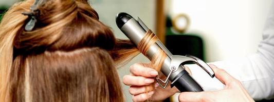 coiffeur curling cheveux avec curling le fer photo