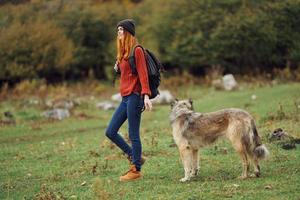 femme avec sac à dos sur sa retour la nature tourisme en marchant chien photo