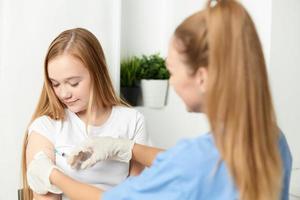 femelle médecin donnant un injection à le les filles main vaccination santé photo