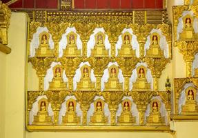 Bouddha statue avec beaucoup petit Bouddha sur le mur dans bouddhiste temple photo