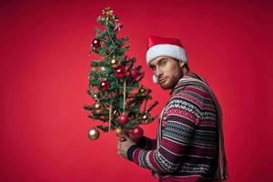 homme avec décoré Noël arbre vacances Noël amusement rouge Contexte photo