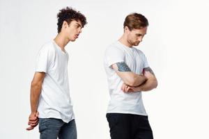 deux Hommes dans blanc t-shirts faire des gestes avec leur mains relation amicale studio photo