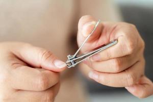 femme Coupe les ongles en utilisant clou tondeuse, soins de santé, beauté concept. photo