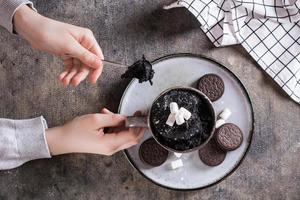 le enfant prend avec une cuillère Chocolat gâteau agresser pour dessert Haut vue photo