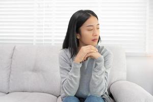 dépression et maladie mentale. femme asiatique déçue, triste après avoir reçu de mauvaises nouvelles. fille stressée confondue avec des problèmes malheureux, se disputant avec son petit ami, pleurant et s'inquiétant d'une grossesse inattendue. photo