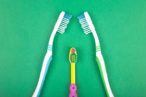 ensemble de brosses à dents pour toute la famille sur fond vert photo