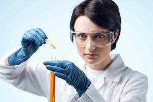 femelle laboratoire assistant dans blanc manteau chimique Solution tester tube science photo