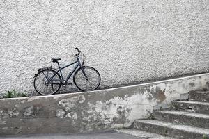 Célibataire vélo penché contre pierre mur, réel paysage urbain photo