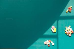 pilules et gélules colorées sur fond vert photo