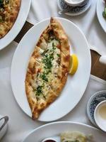 traditionnel turc cuisine Kasarli pide en forme de bateau galette avec fromage, épices et herbes photo