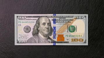 un cent dollar facture sur une noir assiette de face vue financier concept photo