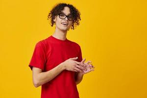 marrant mignonne myope Jeune étudiant homme dans rouge T-shirt lunettes posant isolé sur plus de Jaune studio Contexte. le meilleur offre avec gratuit endroit pour publicité. éducation Université concept photo