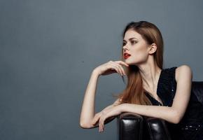 portrait de un élégant femme dans noir robe soir maquillage et rouge lèvres gris Contexte photo