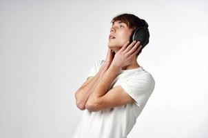 gars dans blanc T-shirt avec écouteurs la musique La technologie lumière Contexte photo