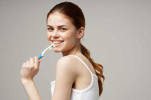 jolie femme dans blanc T-shirt dentaire hygiène santé se soucier lumière Contexte photo