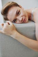 content femme sourire mensonge à Accueil sur le canapé relaxant sur une fin de semaine à Accueil avec une court la Coupe de cheveux cheveux sans pour autant filtres sur une blanc arrière-plan, gratuit copie espace photo