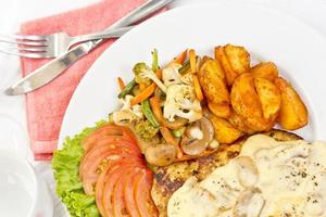 péri péri poulet avec bouton champignon sauce, faire sauter légumes, épicé frit patates avec tomate salade salade. photo