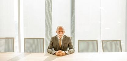 Sénior affaires homme séance dans le salle de réunion à le Bureau photo