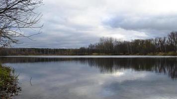 scénique paysage. forêt autour le lac. ondulations sur l'eau. orageux temps. orageux des nuages. ciel, lumière du soleil et des arbres reflétant sur l'eau. photo