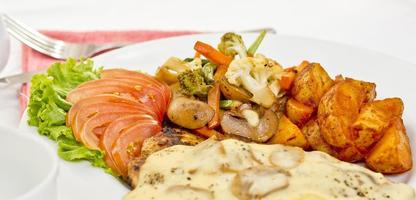 péri péri poulet avec bouton champignon sauce, faire sauter légumes, épicé frit patates avec tomate salade salade. photo