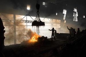 ouvriers fondre métal restes dans le fourneau de une acier moulin à produire tiges dans demra, dacca, Bangladesh. photo