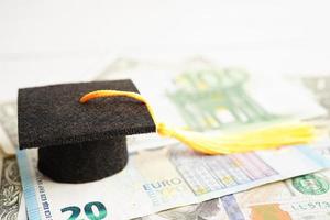 chapeau d'écart de graduation sur l'argent des billets en euros et en dollars américains, frais d'étude de l'éducation apprentissage enseigner le concept. photo