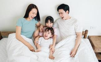 Jeune asiatique famille sur lit photo