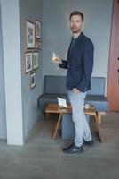 homme avec verre de vin permanent par mur à luxe Hôtel photo