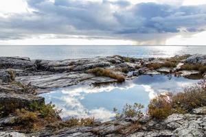 des nuages reflétant dans une bassin de l'eau sur le robuste rive de Lac supérieur à pukaskwa nationale parc, marathon, Ontario photo