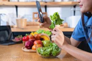 régime, blanc de peau Jeune asiatique femme dans une bleu chemise en mangeant légume salade et pommes comme une en bonne santé régime, opter pour déchet aliments. femelle nutritionniste perdant lester. en bonne santé en mangeant concept. photo