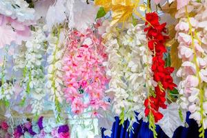 coloré artificiel papier fleurs pendaison sur une organiser. mariage décoration. Plastique coloré décoré fleur. photo