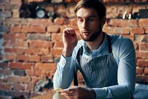 barista dans un tablier dans une café travail un service photo