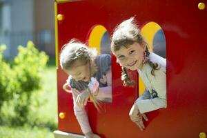 deux marrant les filles de Jardin d'enfants sur une été marcher. six année vieux les enfants jouer sur le Cour de récréation. photo