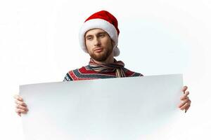 de bonne humeur homme dans une Noël chapeau avec blanc maquette affiche Noël isolé Contexte photo
