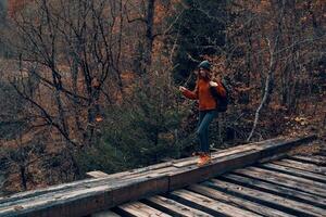 femme touristique des croix le pont plus de le rivière Voyage dans l'automne photo