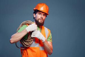 une travail homme dans un Orange peindre corde dans le mains de une construction professionnel photo