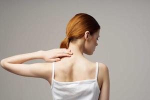 femme dans blanc T-shirt rhumatisme douleur dans le cou santé problèmes isolé Contexte photo