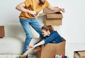 homme et femme dans une Nouveau appartement des boites avec des choses intérieur photo