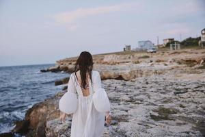 femme dans blanc robe marcher la nature paysage du repos rochers photo
