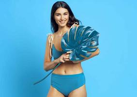 de bonne humeur femme dans une bleu maillot de bain paume feuille exotique bleu Contexte photo