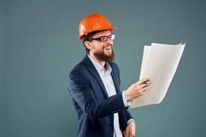 une homme dans Orange peindre plans dans le mains de une construction industrie officiel photo