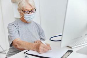 personnes âgées femme portant une médical masque hôpital rendez-vous à voir une médecin photo