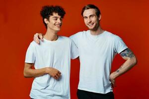 marrant deux copains dans blanc t-shirts posant studio photo