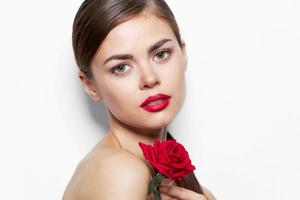 Jeune femme nu épaules et rouge lèvres Rose fleur Regardez devant brillant maquillage photo