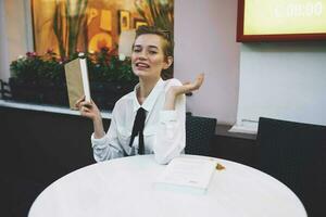 court aux cheveux femme avec une livre dans le sien mains en train de lire mode de vie photo