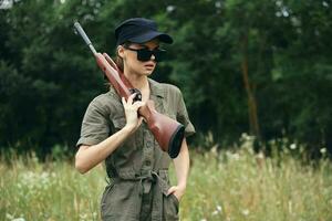 militaire femme femme avec armes dans foncé des lunettes vert combinaison Frais air photo