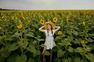 femme portrait dans une blanc robe en marchant sur une champ de tournesols paysage photo